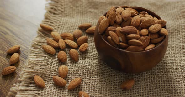 Video of almonds in a bowl on wooden background