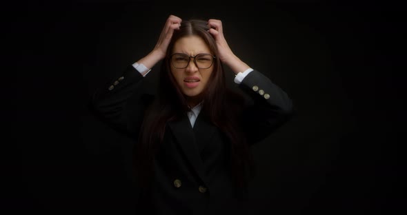 Aggressive Businesswoman Tearing Her Hair on Her Head Black Background