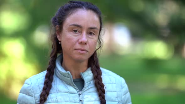 Portrait of Tired Middle-aged Woman Outdoors, Looking at Camera