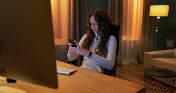 Attractive Brunette with Curly Hair at a Young Age Sitting Comfortably on a Chair in