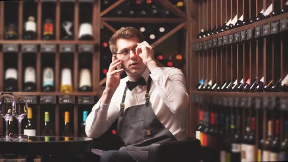 Elegant Young Sommelier in a Wine Boutique Makes Online Sales