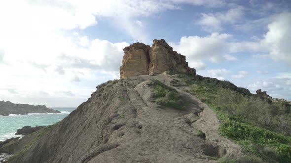 Slowly Climbing to Il-Qarraba Rock on Path Formed from Hardened Mud