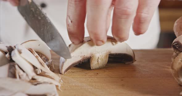 Close up of a chef knife slicing a portobello mushroom