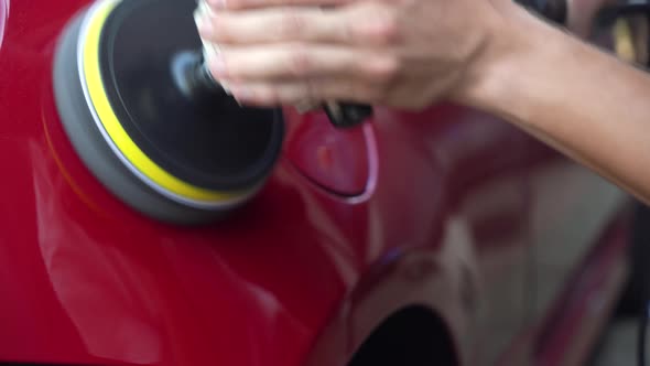 polishing a car body with a polishing machine.