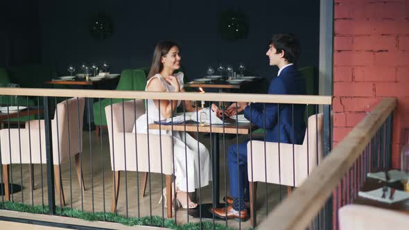 Beautiful Couple Man and Woman Are Enjoying Date in Restaurant