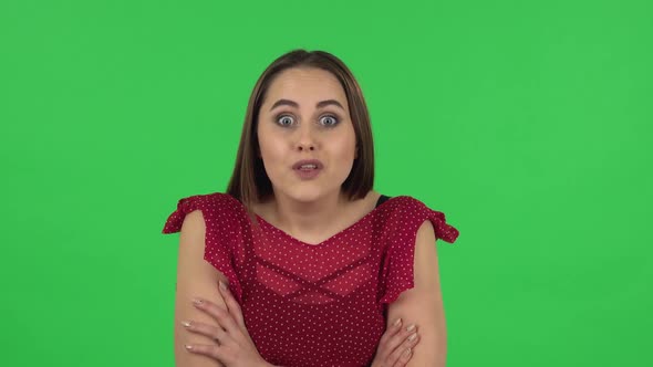 Portrait of Tender Girl in Red Dress Is Listening To Information, Shocked and Smiling. Green Screen