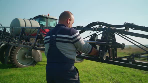 Farmer Prepares an Agricultural Sprayer for Work