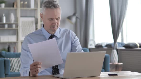 Gray Hair Businessman Writing on Paper at Work Paperwork