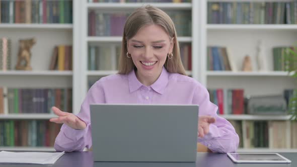 Woman Talking on Video Call on Laptop in Office