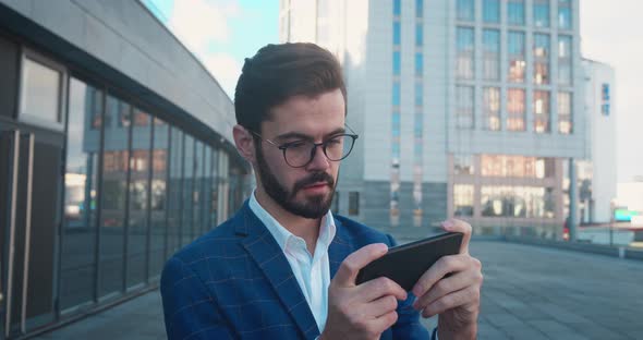 Businessman Playing Video Game on Smartphone