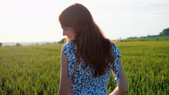 Beautiful Ginger Girl Walking in Wheat Field in Summer