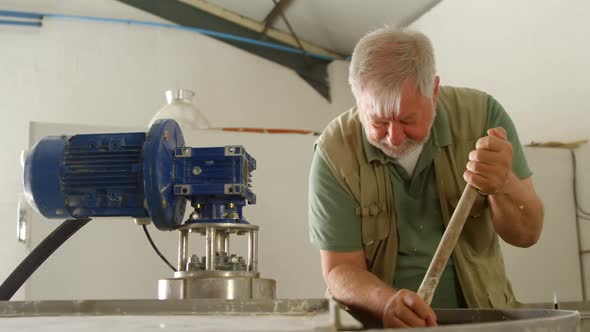 Male worker stirring gin in distillery 4k