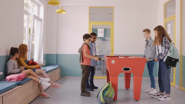 Boy Playing Table Football with Other Children at the Break in School