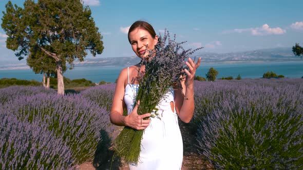 Woman Smelling The Flowers In Lavender Field