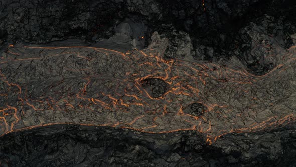 Aerial view on top of a magma river, on a lava field - birds eye, drone shot