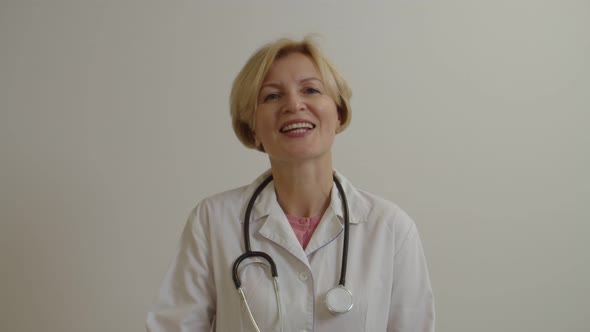 Portrait of Confident Middle Aged Female General Practitioner Looking with Friendly Smile at Clinic