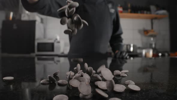 Chef Chocolatier Pours Dark Chocolate Drops To the Marble Table in Slow Motion, Raw Materials for