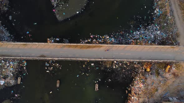 Road crossing a polluted river. Locals have problems with garbage collection. Son Hai town, near Pha