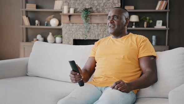 Elderly Single Bachelor African American Adult Senior Man Sitting on Couch Watching TV Enjoy Serial