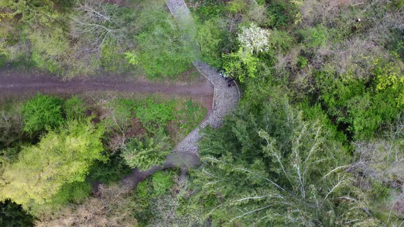 Two people are sitting on path in a park. Unbelievable aerial view flight rotation 360 Drone top-dow