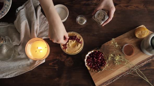 A Young Girl Cooked a Traditional Hummus in Her Kitchen and Strew It with Spices. Close-up. View