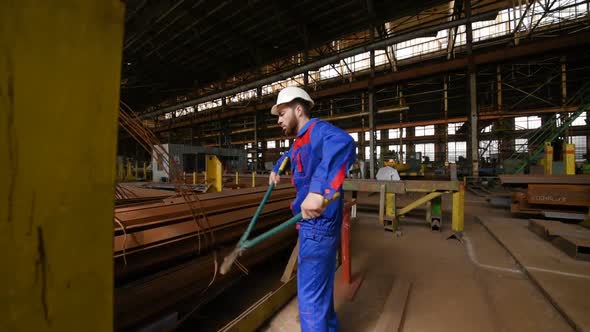 Worker in a White Helmet Bites the Steel Wire with Wire Cutters