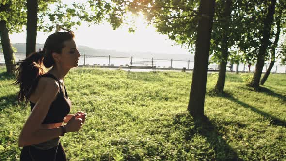 Athletic Girl Running in the Park and Doing Exercises Jogging