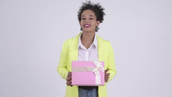 Happy Young Beautiful African Businesswoman Thinking While Holding Gift Box