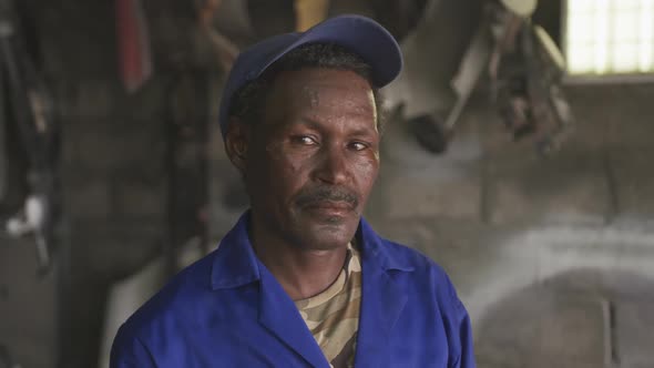 Old African handyman looking at camera