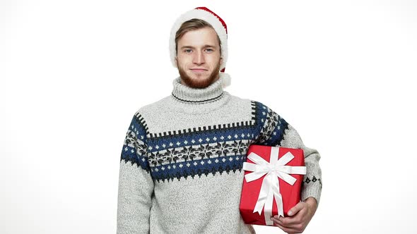 Slow-motion Young Handsome Man Holding Present and Smile To Camera on Christmas Day.