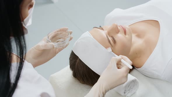 Cosmetologist Doing Procedures Moisturizing Face for Woman