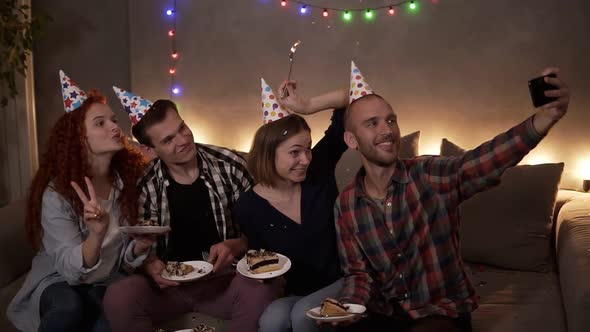 Cheerful Young Friends or Two Couples Having Small Cozy Birthday Celebration Sitting Together in