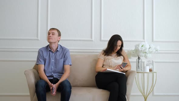 Man and Woman Sitting on Sofa in Waiting Area