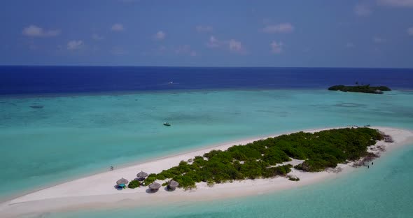 Daytime aerial travel shot of a white sandy paradise beach and blue sea background in colorful 4K