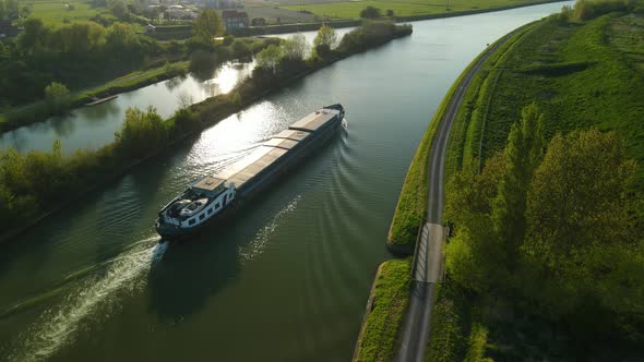 Aerial view of a houseboat on a river near a field in Clairmarais, France.There is a village on the