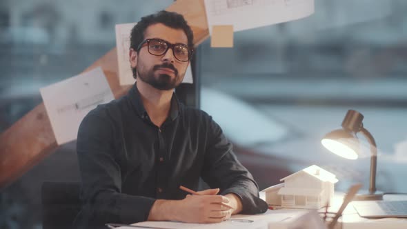 Young Arab Male Architect Drawing Floor Plan and Posing for Camera