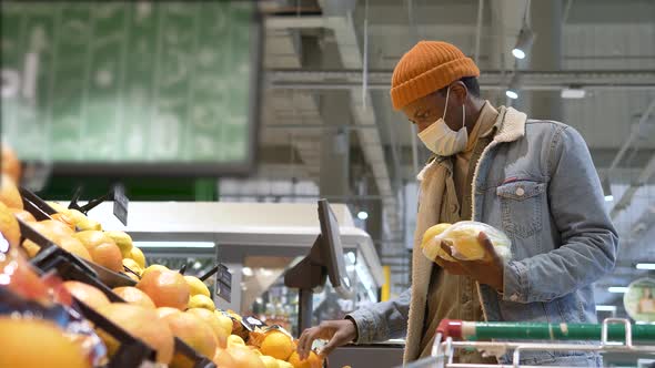 Professional Shopper in Face Mask Chooses Yellow Lemons