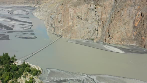 Aerial top down view of tourists crossing the famous Hussaini bridge in Hunza Pakistan with a fast r
