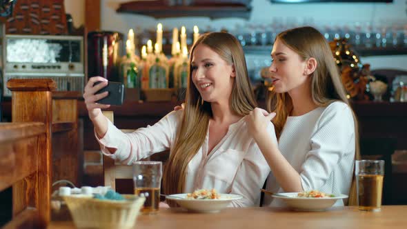 Two Beautiful Women Taking Selfie in Cafe