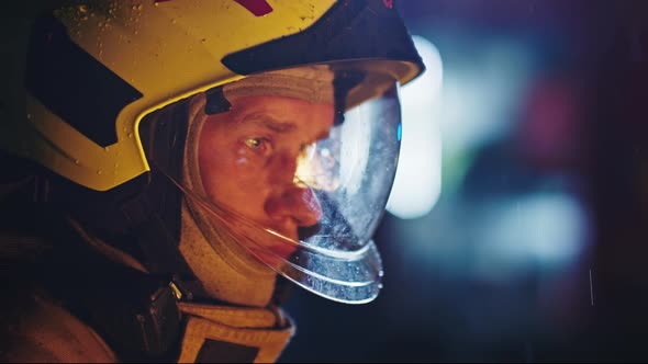 Portrait Shot of a Fireman in Action in Full Uniform. Turning His Head Away From the Camera. Face