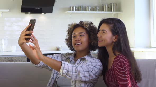 Asian and African American Black Woman Taking Selfie Using Smartphone
