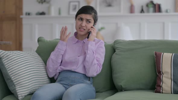 Angry Indian Woman Talking on Phone on Sofa