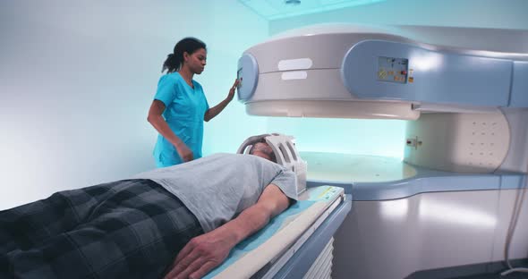 Black Female Doctor Preparing Senior Male Patient to Brain MRI
