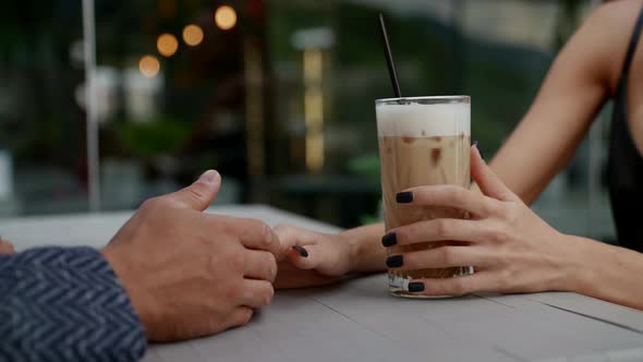 a Couple is Sitting at a Table in an Outdoor Cafe