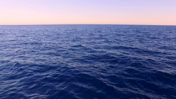 Aerial view of sea. Tropical romantic sunset over the ocean. POV of the back of a ship or yacht. Dro