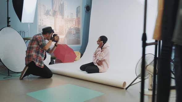 Backstage of the Photo Shoot: Black Model Posing on the Floor for a Photographer