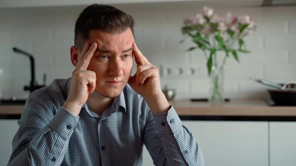 Stressed frustrated 30s young adult businessman suffering from headache at work