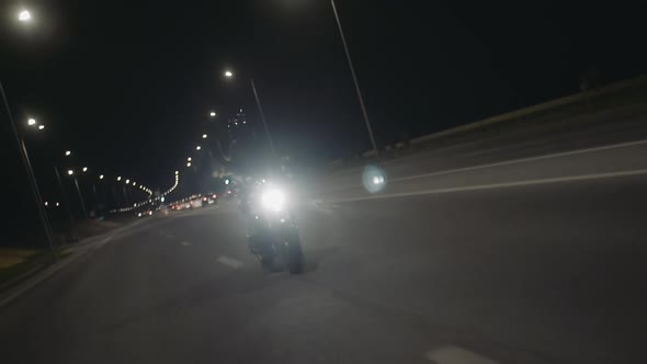 Female Biker with Super Sport Motorcycle Riding Fast on City Road at Night