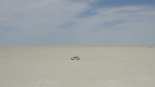 SUV Car Driving On Dry Kubu Island In The Makgadikgadi Pan Area Of Botswana. Wide Shot