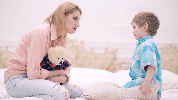 Mother and Son Little Boy Talk in the Bedroom. Concept of Family Communication. Mother's Day. Child